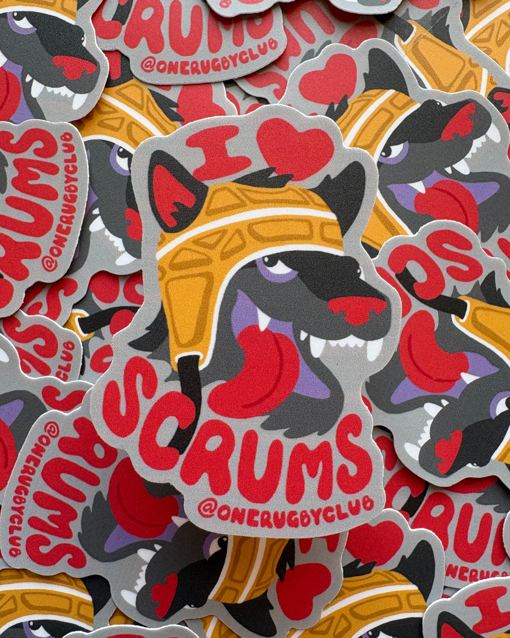 Pile of stickers of a wolf in a scrum cap with the words "I love scrums"