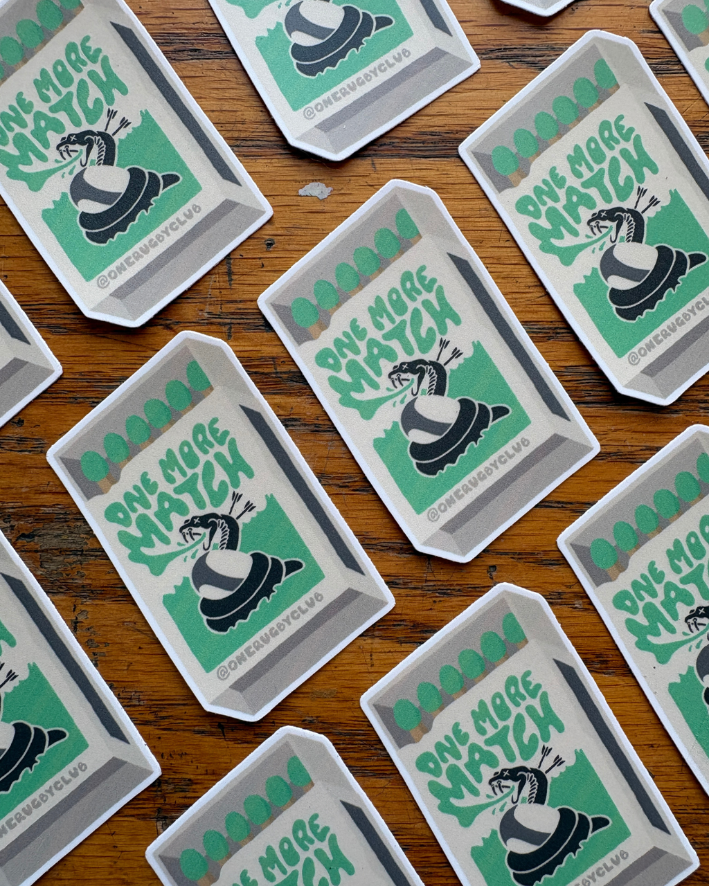 Repeating rows of stickers of matchbox with venomous snake and the words "One more match"
