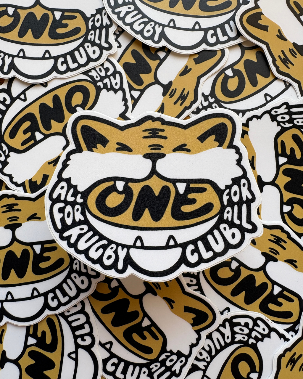 Pile of stickers of cartoon tiger biting down on a rugby ball
